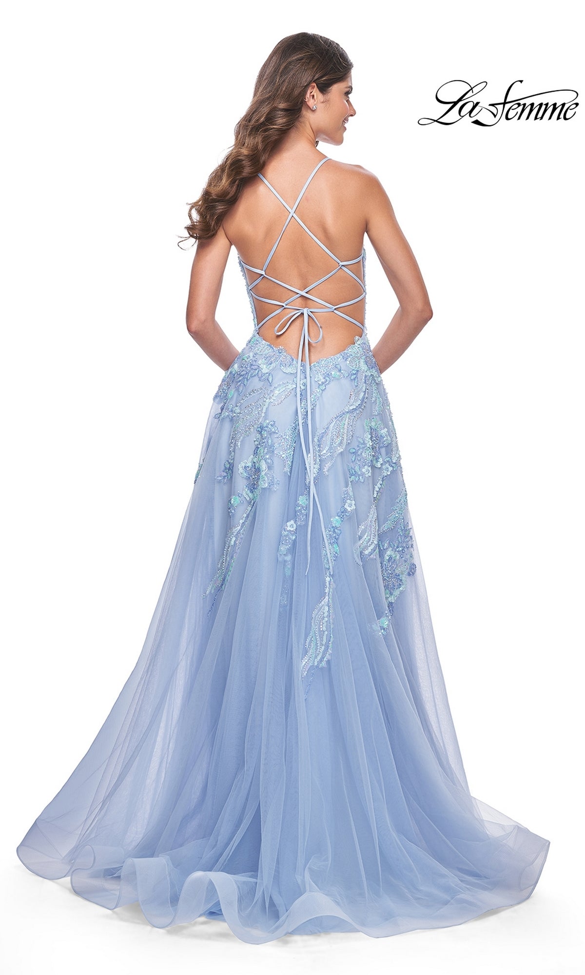 Woman in a light blue La Femme Sequin-Lace Long A-Line Prom Dress 32032, featuring lace details, an open back, and crisscross straps, standing with her back to the camera.